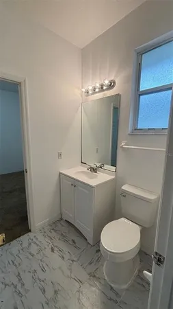 a bathroom with a sink a toilet and mirror