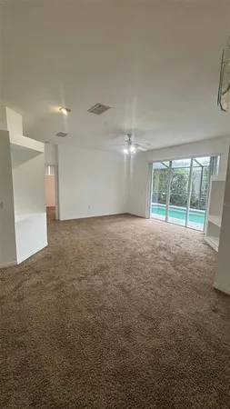 a view of an empty room with glass door and a balcony