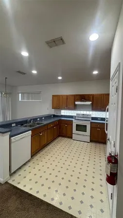 a kitchen with stainless steel appliances a sink a stove top oven a counter space and cabinets