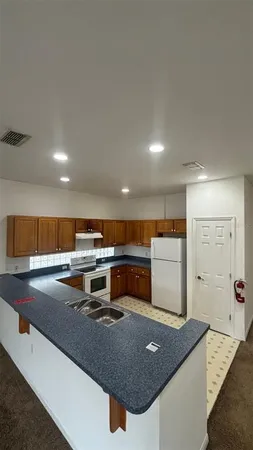 a view of kitchen island with stainless steel appliances granite countertop sink stove and cabinets
