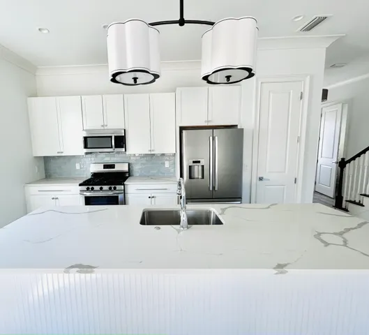 a large kitchen with granite countertop a stove a sink a window and a dining table