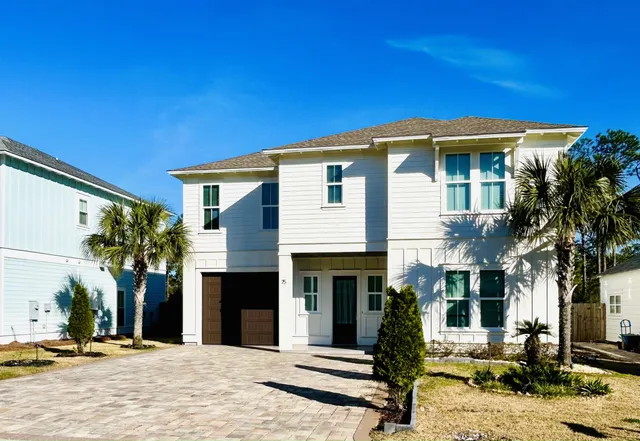 a front view of a house with a tree