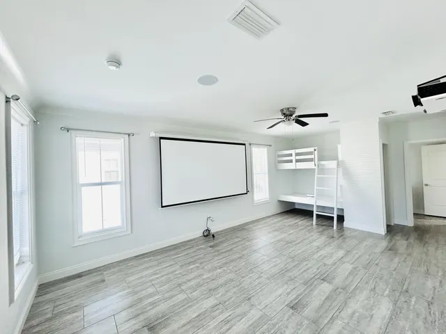 a view of empty room with windows and wooden floor