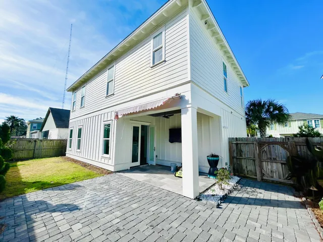 a view of a house with backyard and sitting area