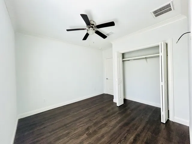 a view of empty room with wooden floor and window