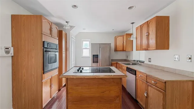 a kitchen with stainless steel appliances granite countertop a sink stove and refrigerator