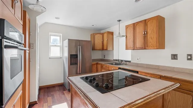a kitchen that has a sink a counter space and stainless steel appliances