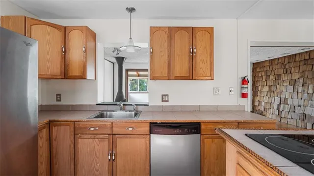 a kitchen with stainless steel appliances granite countertop a sink stove and refrigerator