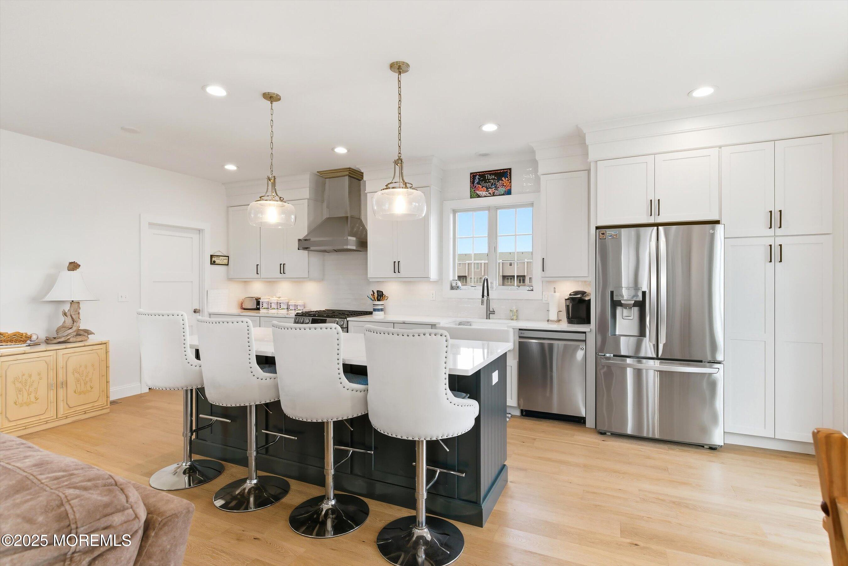 7 East Lavenia Avenue Beach Haven, NJ 08008 - Photo 14 of 48 a kitchen with stainless steel appliances granite countertop a sink a stove a refrigerator and island with wooden floor
