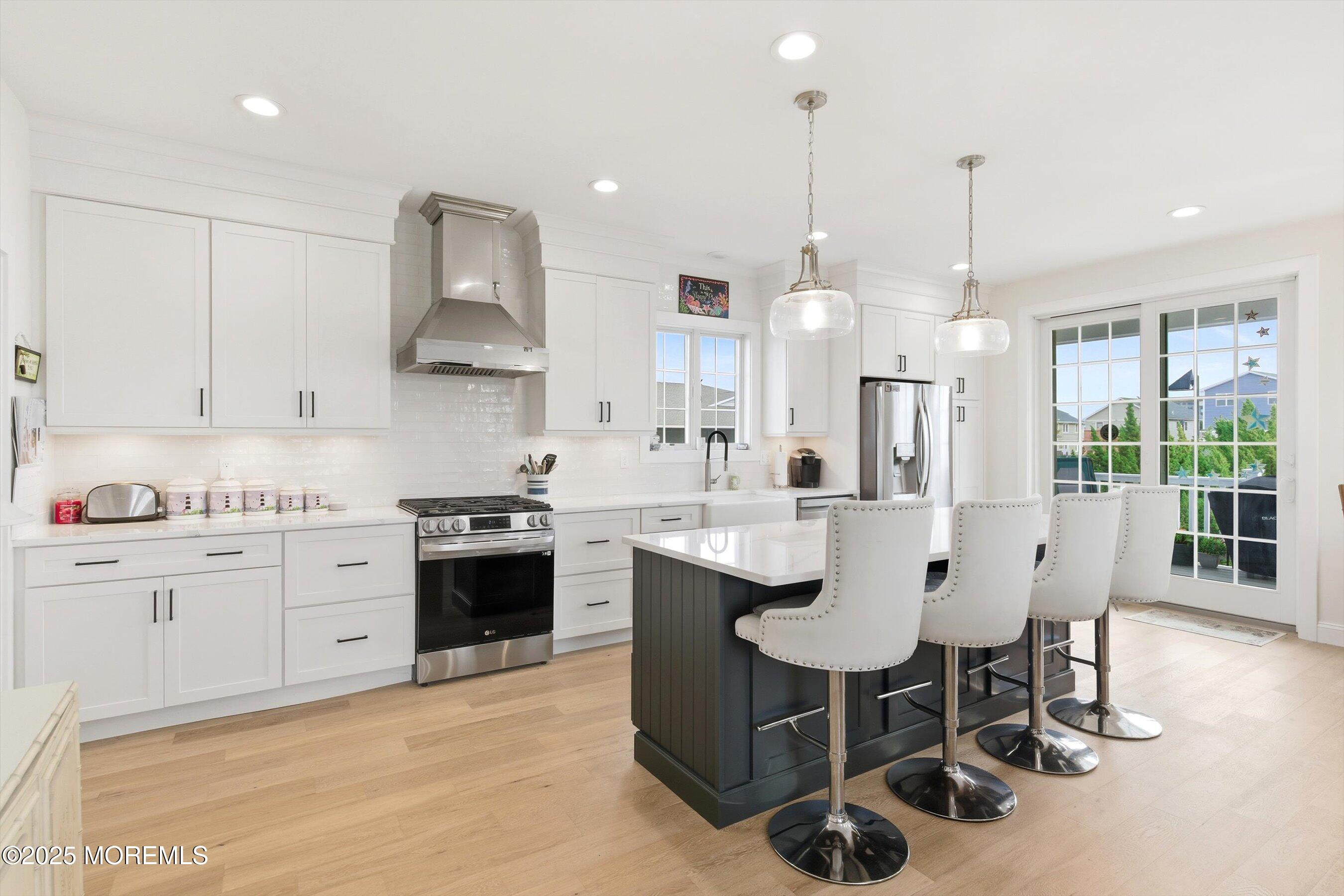 7 East Lavenia Avenue Beach Haven, NJ 08008 - Photo 15 of 48 a kitchen with stainless steel appliances granite countertop a sink a stove a refrigerator and island with wooden floor