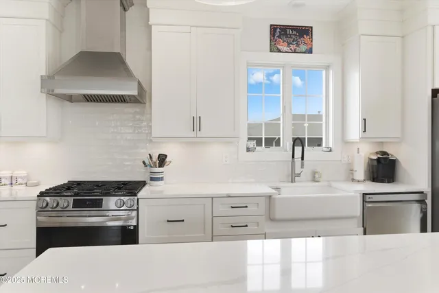 a kitchen with stainless steel appliances a sink stove and cabinets