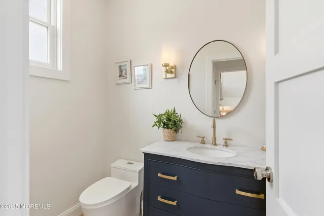 a bathroom with a toilet a sink and a mirror