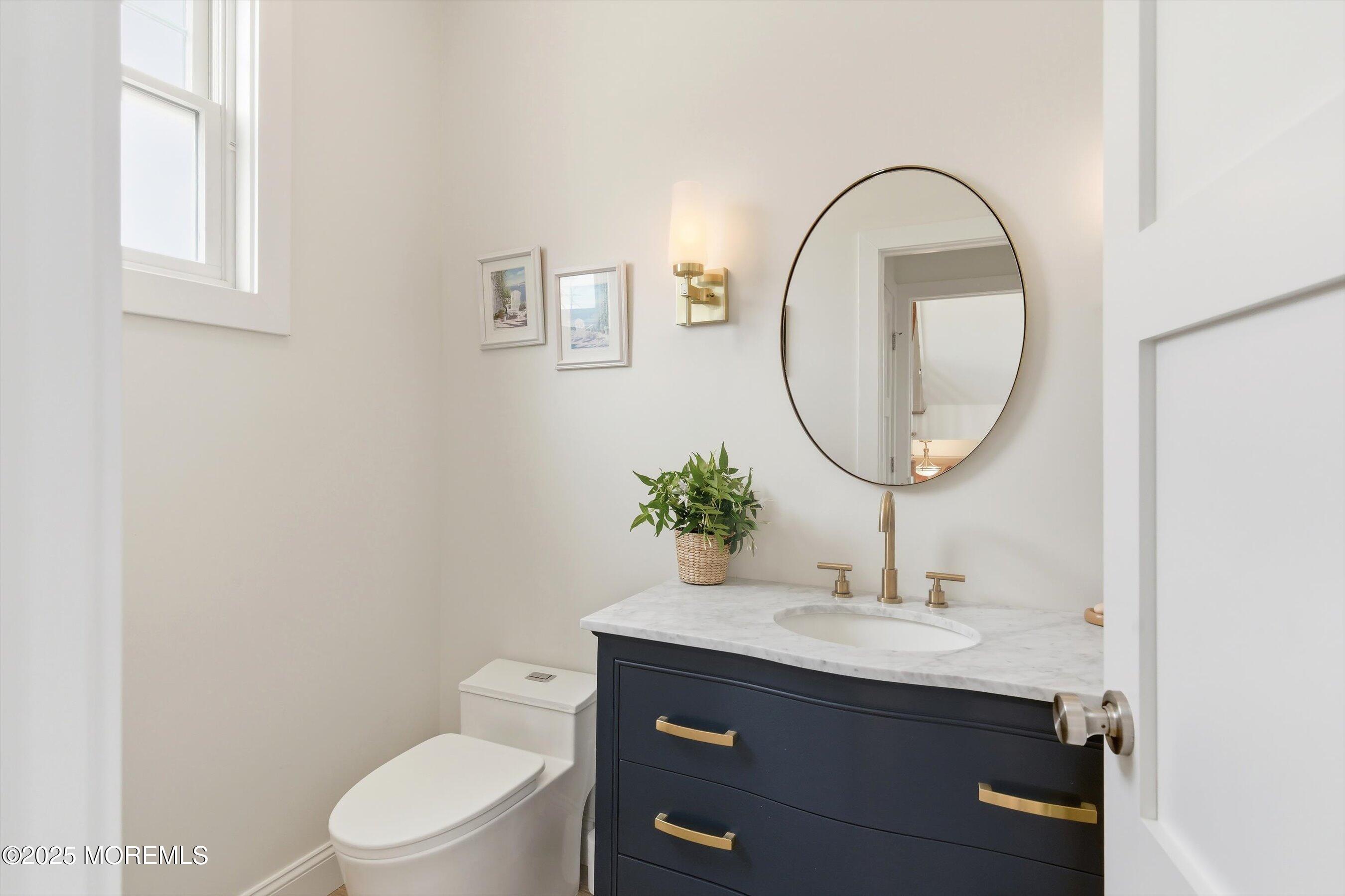 7 East Lavenia Avenue Beach Haven, NJ 08008 - Photo 17 of 48 a bathroom with a toilet a sink and a mirror