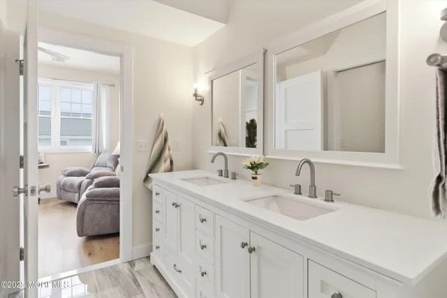 a en suite bathroom with a double vanity sink and a mirror