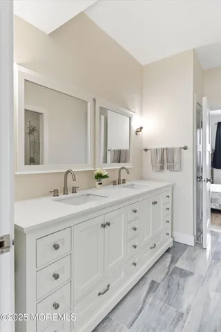 a bathroom with double sink and a mirror
