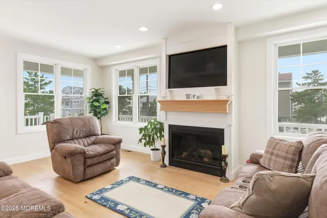 a living room with furniture a flat screen tv and a fireplace
