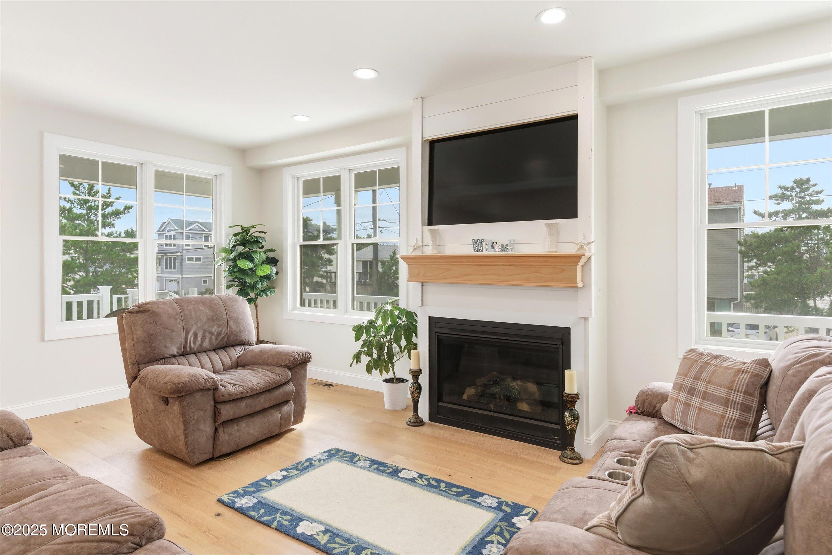 7 East Lavenia Avenue Beach Haven, NJ 08008 - Photo 9 of 48 a living room with furniture a flat screen tv and a fireplace