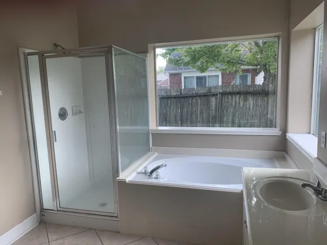 a bathroom with a tub a sink and a mirror