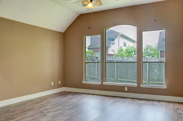 a view of a livingroom with wooden floor and a large window