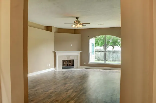 an empty room with a fireplace and windows