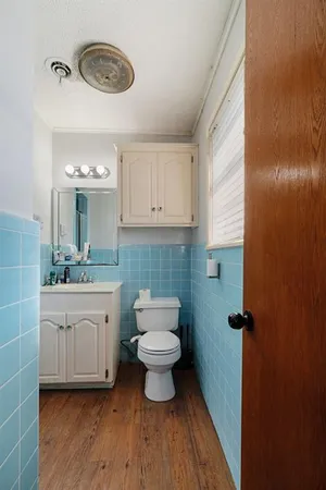 a bathroom with a toilet sink and mirror