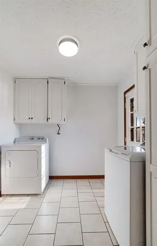 a utility room with cabinets washer and dryer