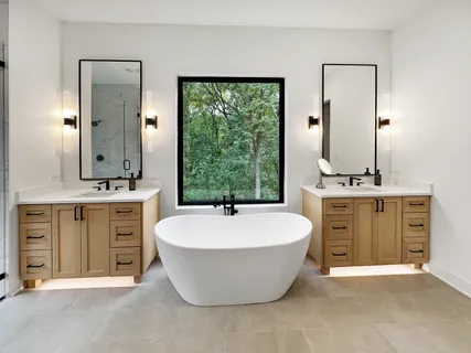 a spacious bathroom with a double vanity sink large mirror and bathtub