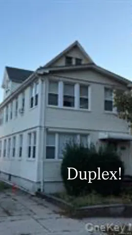 a front view of a house with plants