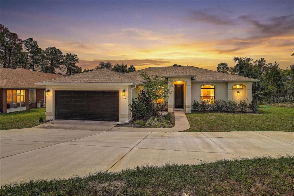 7314 Madrid Road Weeki Wachee, FL 34613 - Photo 1 of 54 a front view of a house with a yard and garage
