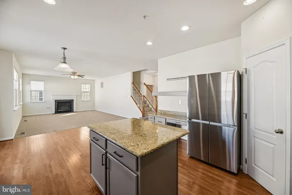 a kitchen with kitchen island a sink stainless steel appliances and wooden floor