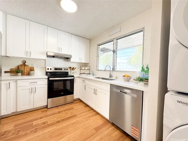 a kitchen with granite countertop white cabinets and white appliances