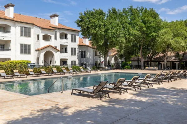 a front view of a house with swimming pool and sitting area
