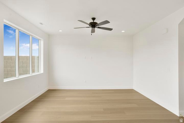 990 Manen Street Washington, UT 84780 - Photo 11 of 43 Bright room featuring a large window, a modern ceiling fan, recessed lighting, wood-finish flooring, and crisp white walls