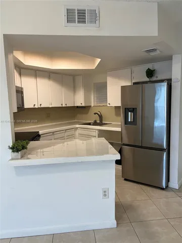 a kitchen with stainless steel appliances granite countertop a sink and a refrigerator