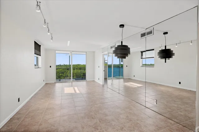 a view of an empty room with a windows and ceiling fan