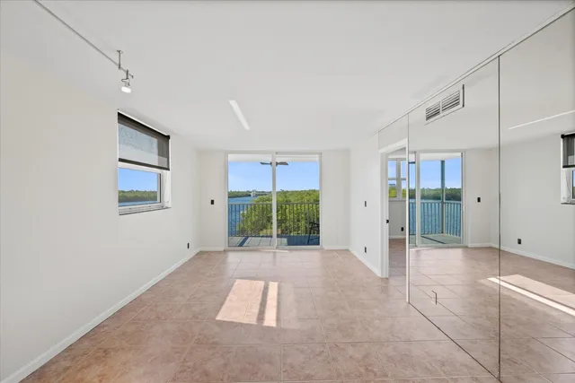 a view of an empty room with window and bathroom