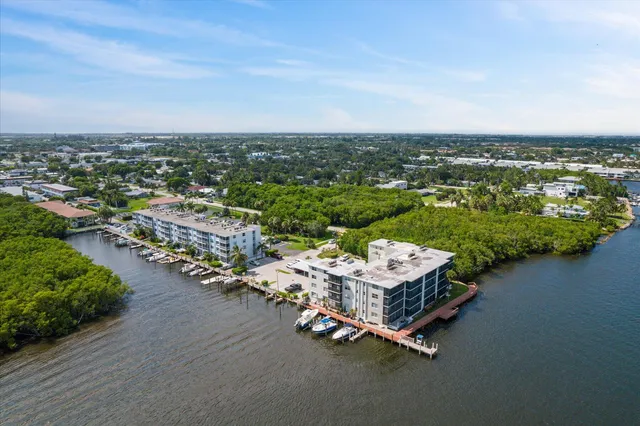 an aerial view of a city with lots of residential buildings ocean and mountain view in back