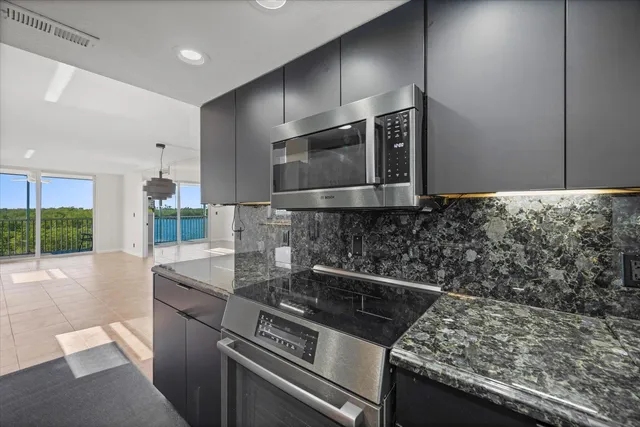 a kitchen with granite countertop a sink and stainless steel appliances