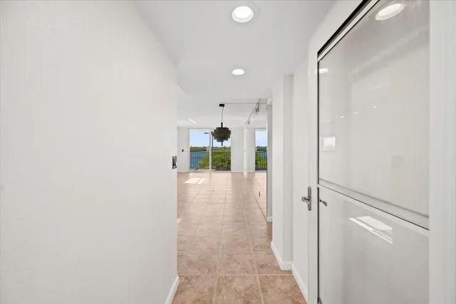 a view of a hallway with a dining table & chairs