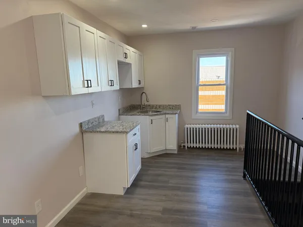 an empty room with wooden floor and a window