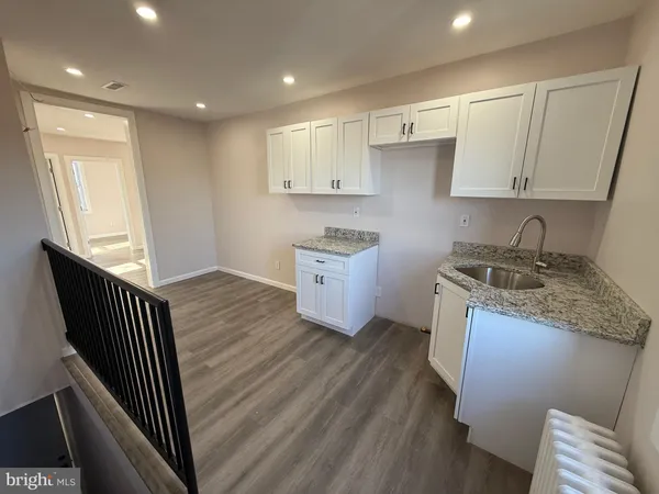 a kitchen with granite countertop sink stove and cabinets