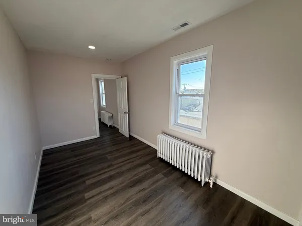 a view of a hallway with wooden floor and stairs