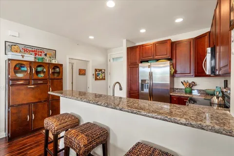 a kitchen with stainless steel appliances granite countertop a refrigerator and a sink