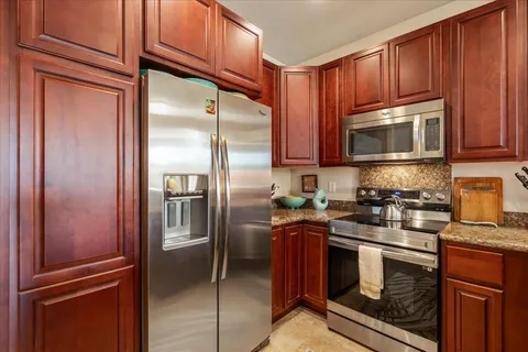 a kitchen with granite countertop a refrigerator stove and microwave
