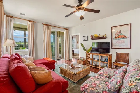 a living room with furniture a flat screen tv and a floor to ceiling window