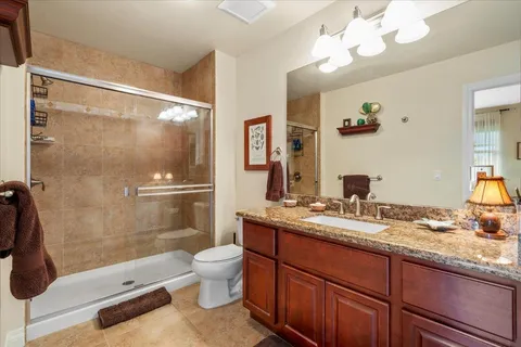 a bathroom with a granite countertop sink toilet and shower