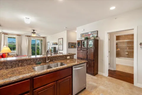 a kitchen with stainless steel appliances granite countertop a sink and a refrigerator