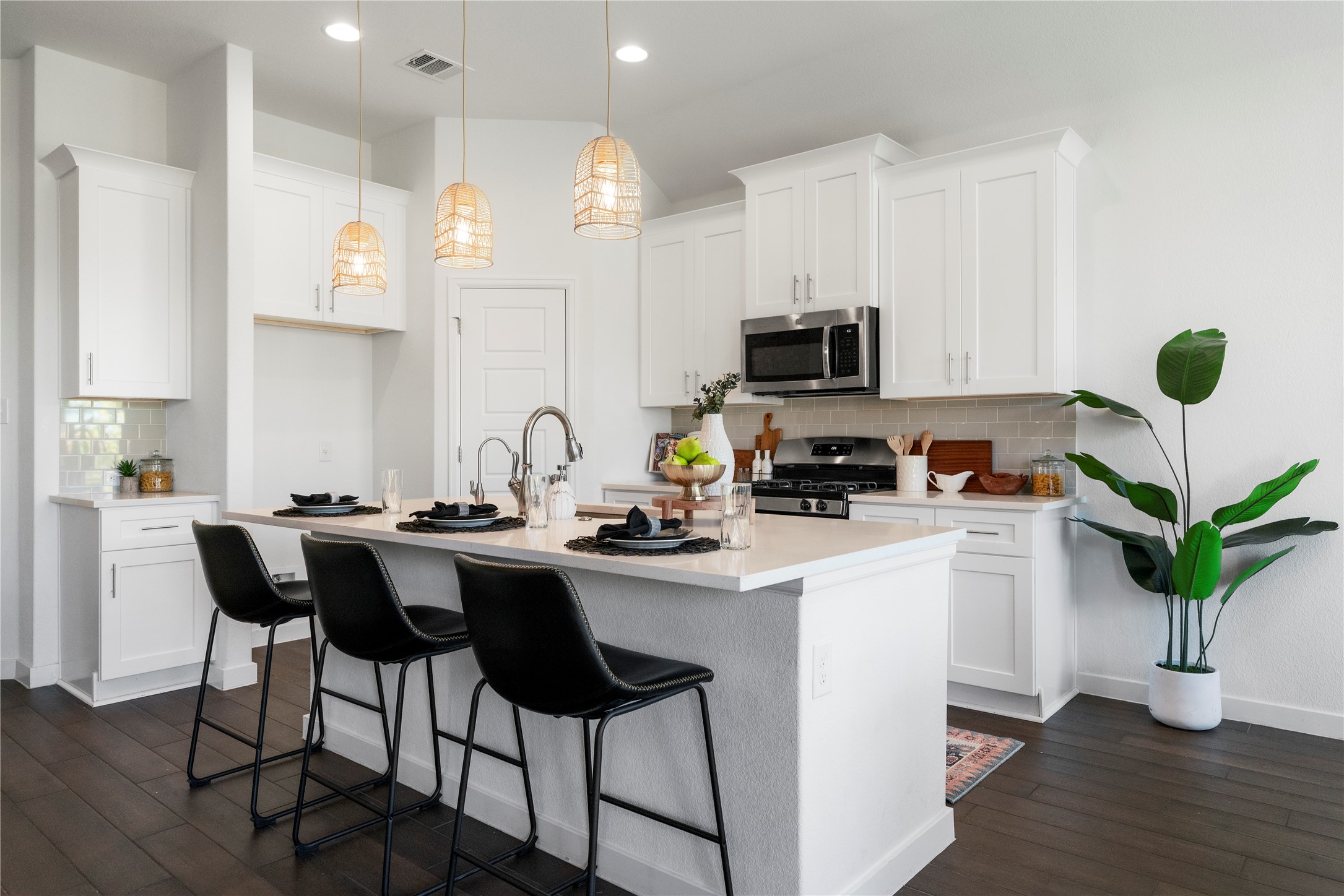 2021 Josiah Cove Leander, TX 78641 - Photo 13 of 35 Kitchen featuring a breakfast bar area, backsplash, stainless steel appliances, a center island with sink, and white cabinetry