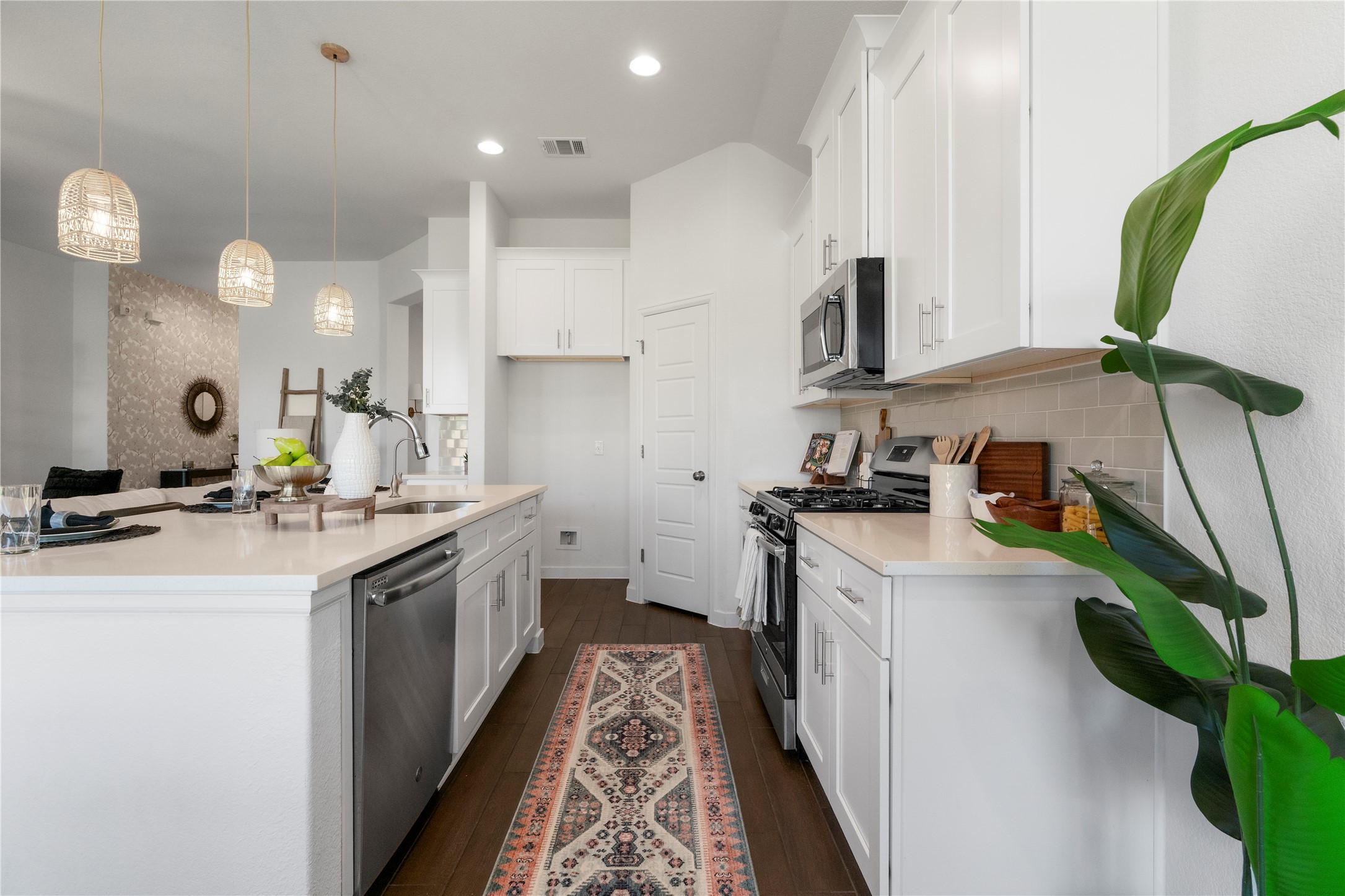 2021 Josiah Cove Leander, TX 78641 - Photo 15 of 35 Kitchen with appliances with stainless steel finishes, hanging light fixtures, white cabinets, a center island with sink, and dark wood finished floors