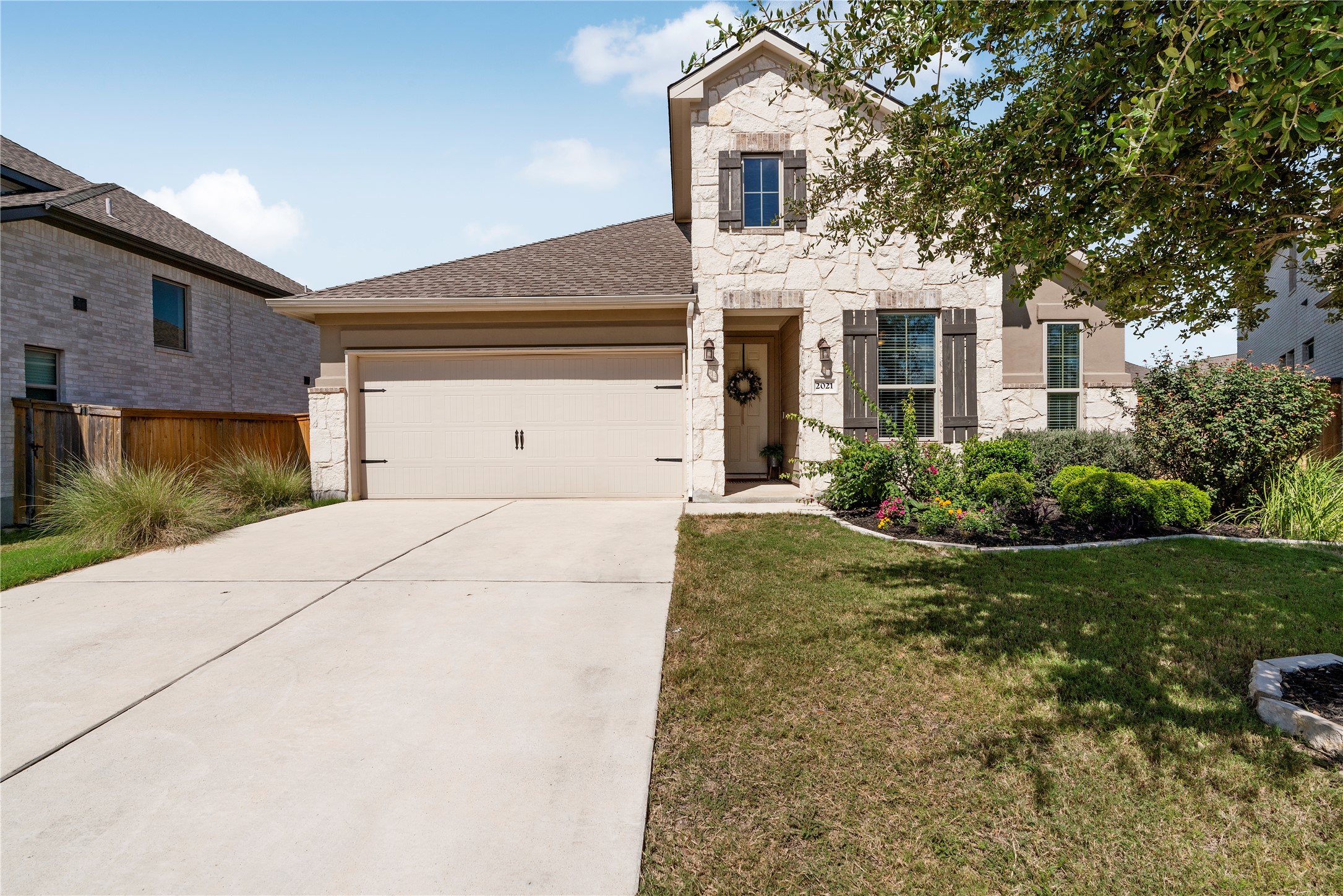 2021 Josiah Cove Leander, TX 78641 - Photo 3 of 35 View of front of home featuring stone siding, concrete driveway, and a garage